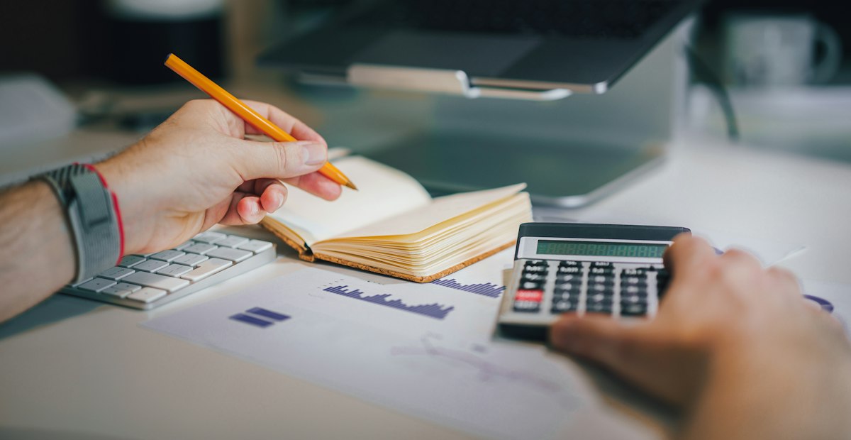 A calculator and notebook on a desk